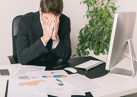 stock-photo-stressed-young-businessman-at-office-184771061